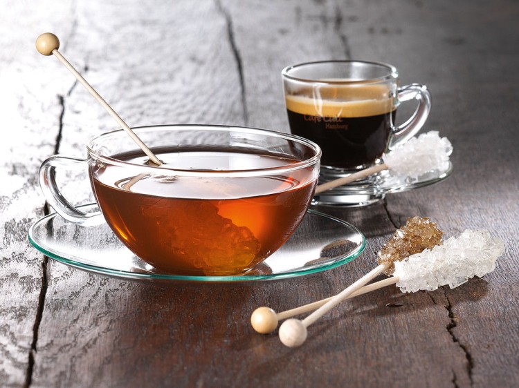 Cukier kandyzowany brązowy na patyczku w filiżance herbaty i przy espresso